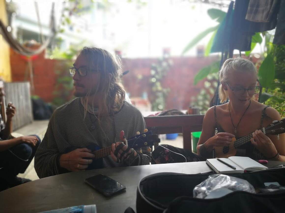 Laura and Ziggy playing ukueles in the garden of a gueshouse