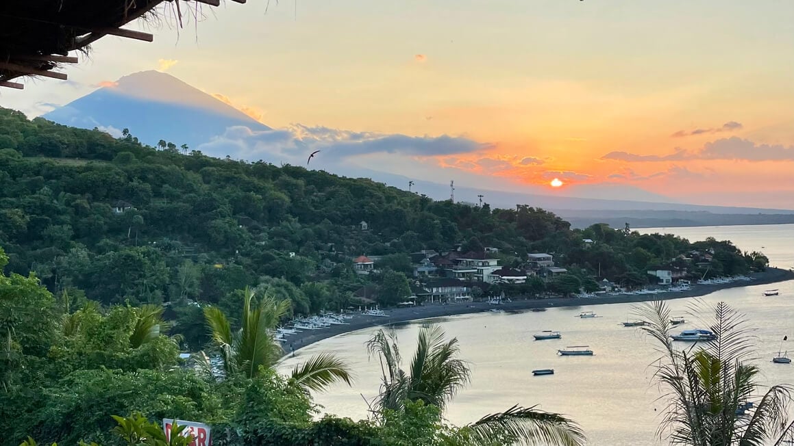sunset view in amed across the hills, sea and mount agung, bali, indonesia