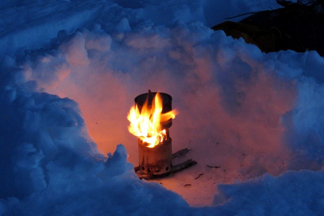 a top rated backpacking stove cooking in the snow