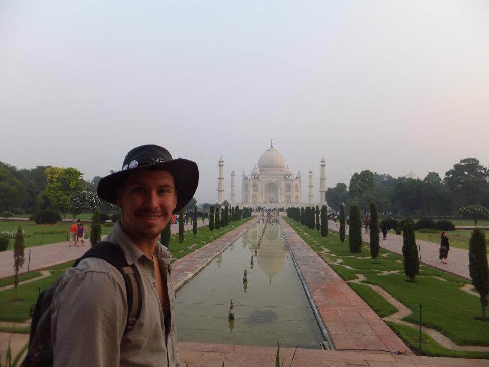 young will standing with the taj mahal in the background