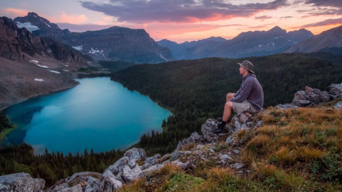 man sitting and overlooking the beautiful lake landscape at banff national park alberta canada