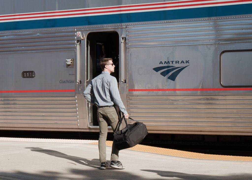 A man carrying the Nomatic Travel Bag as a duffel bag