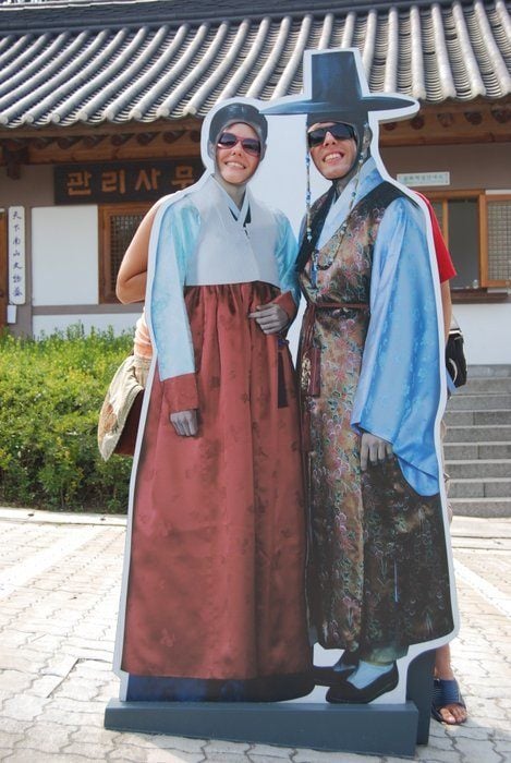 Two people taking a photo op in traditional Korean dress making the most of Korean Culture