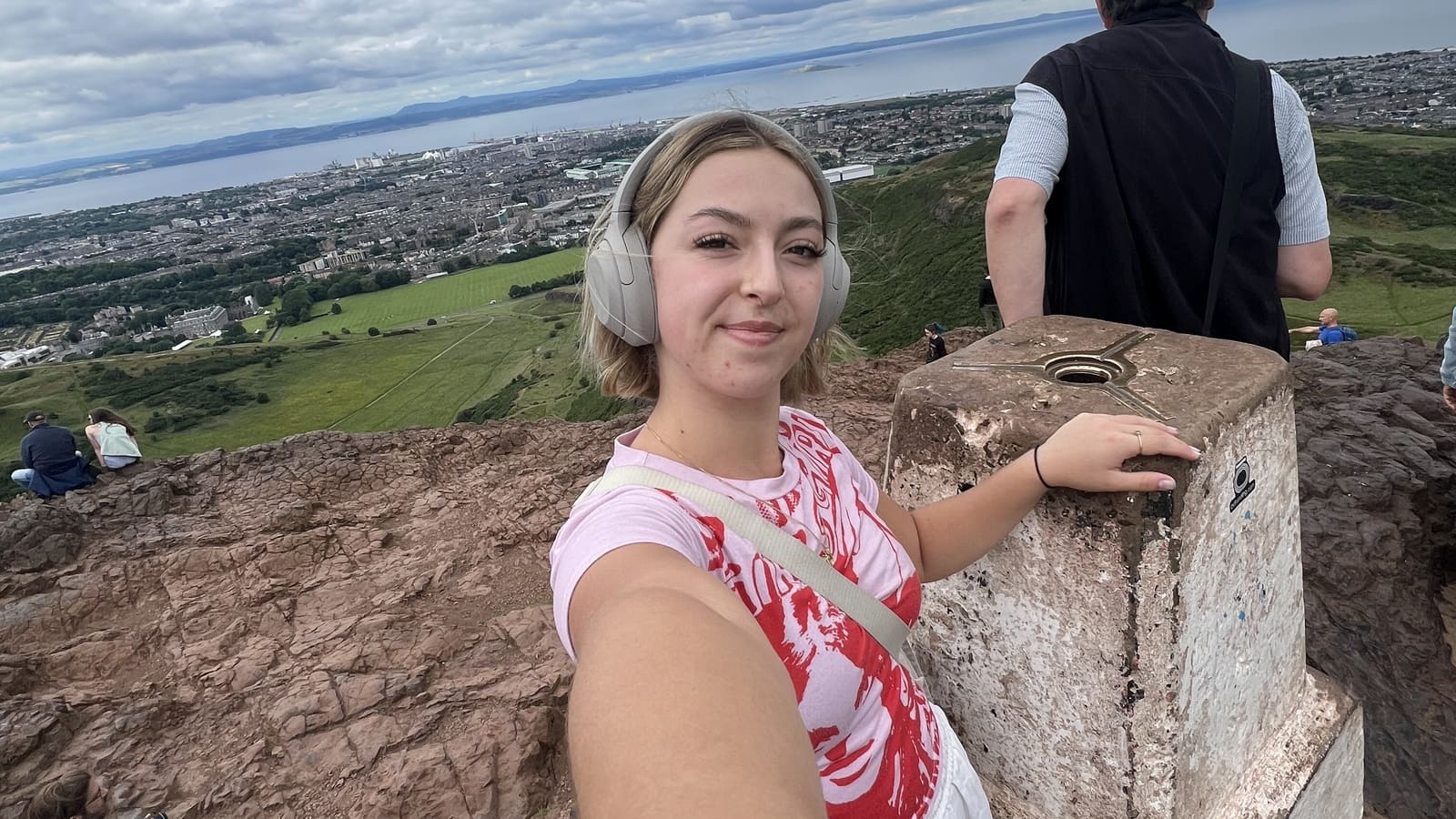 taya posing at the top of arthurs seat, edinburgh