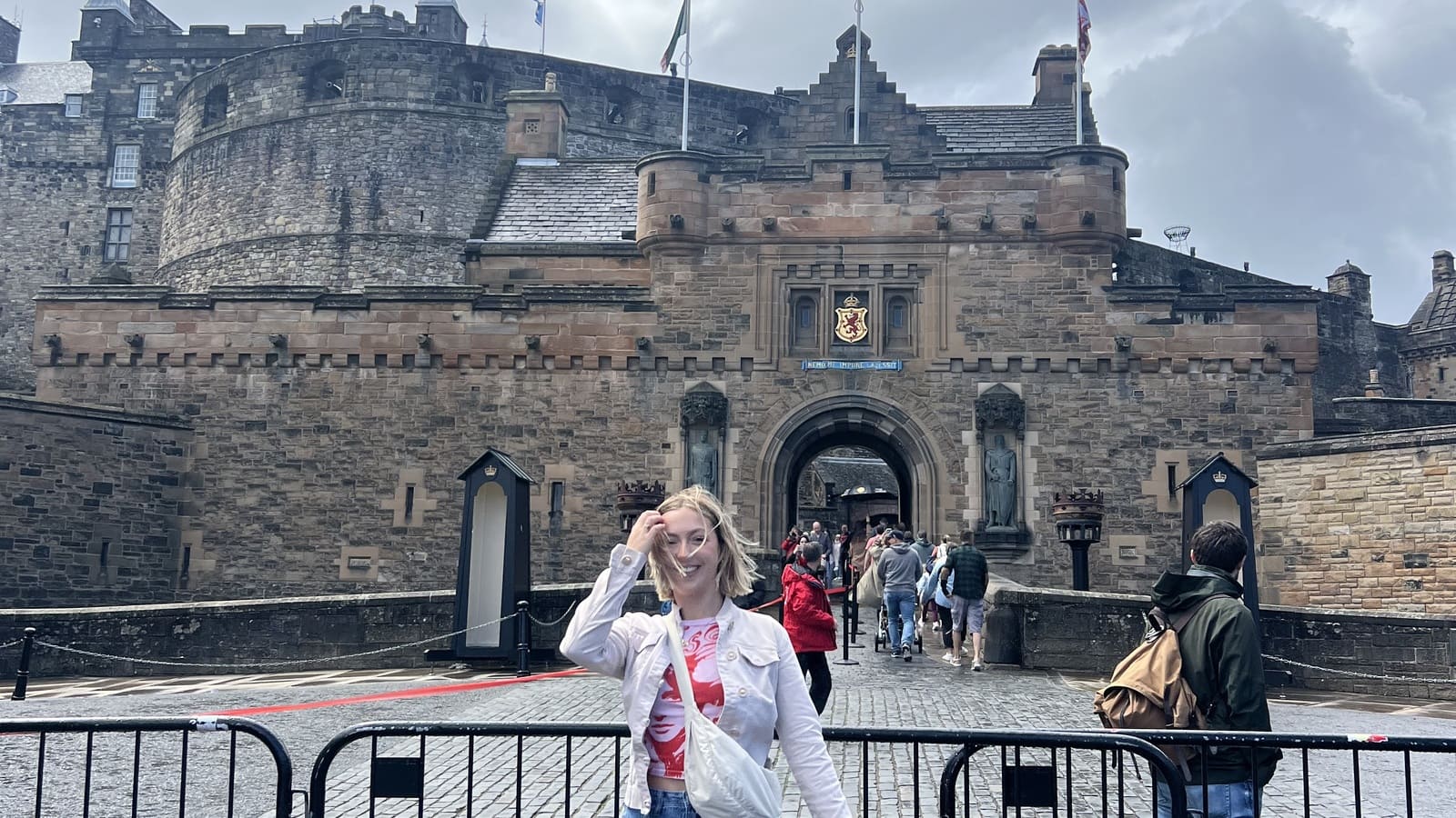 girl posing in front of edinburgh castle on a windy day