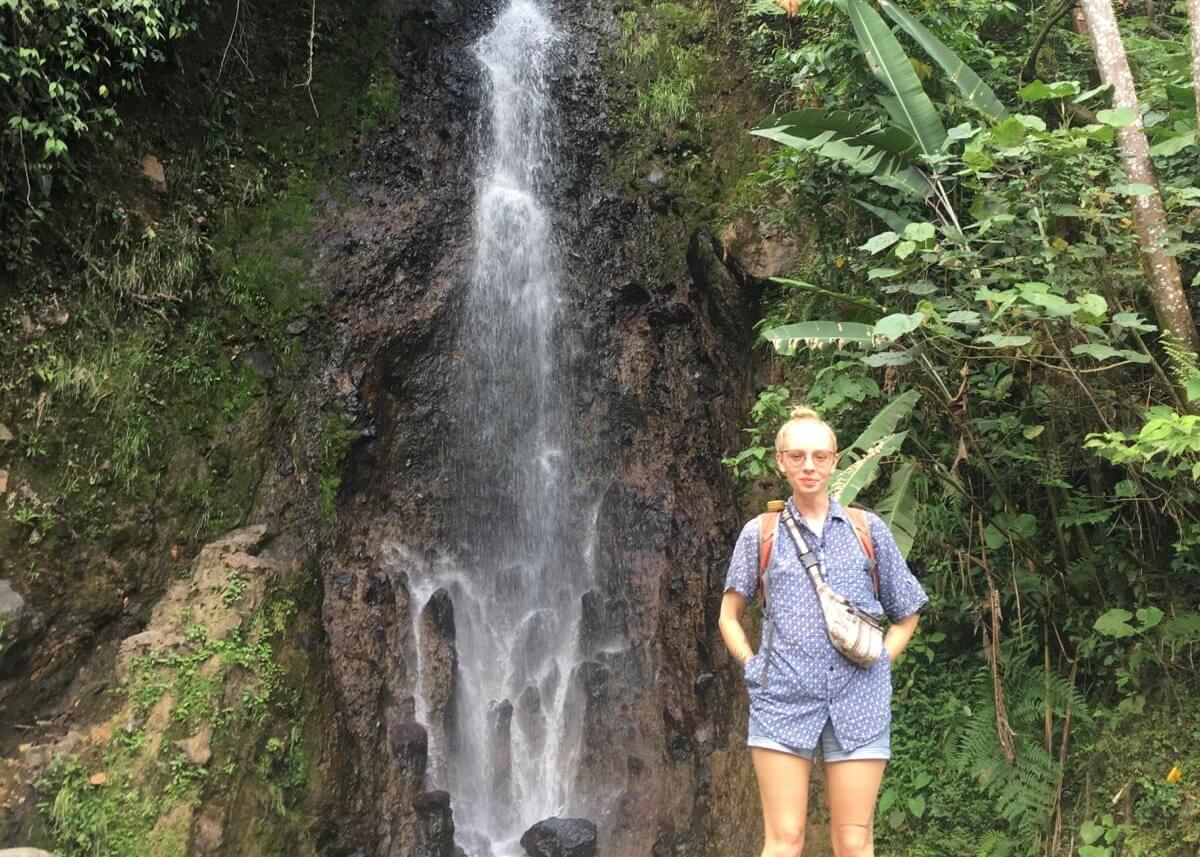 Laura stood smiling in front of a waterfall in Antioquia, Colombia