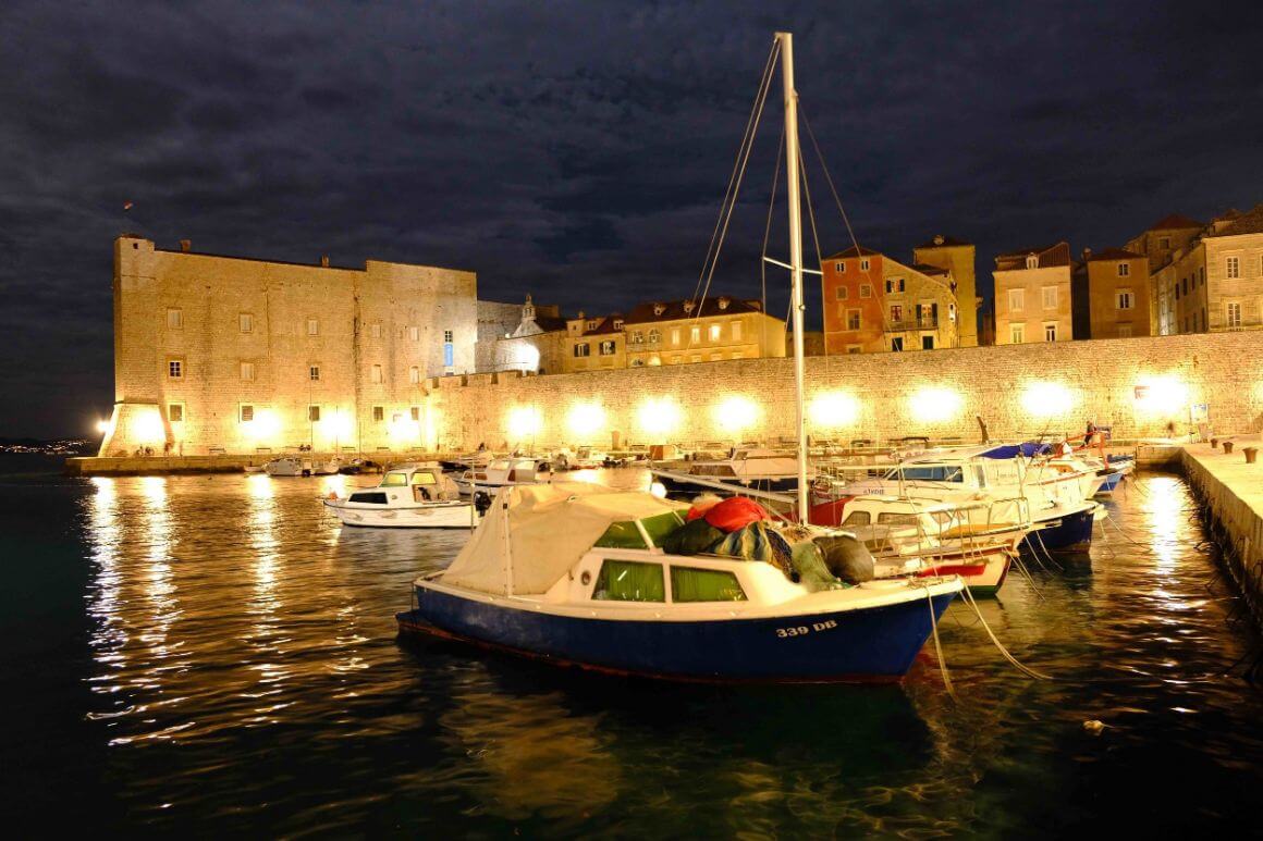 A boat in Dubrovnik harbour at night being lit up