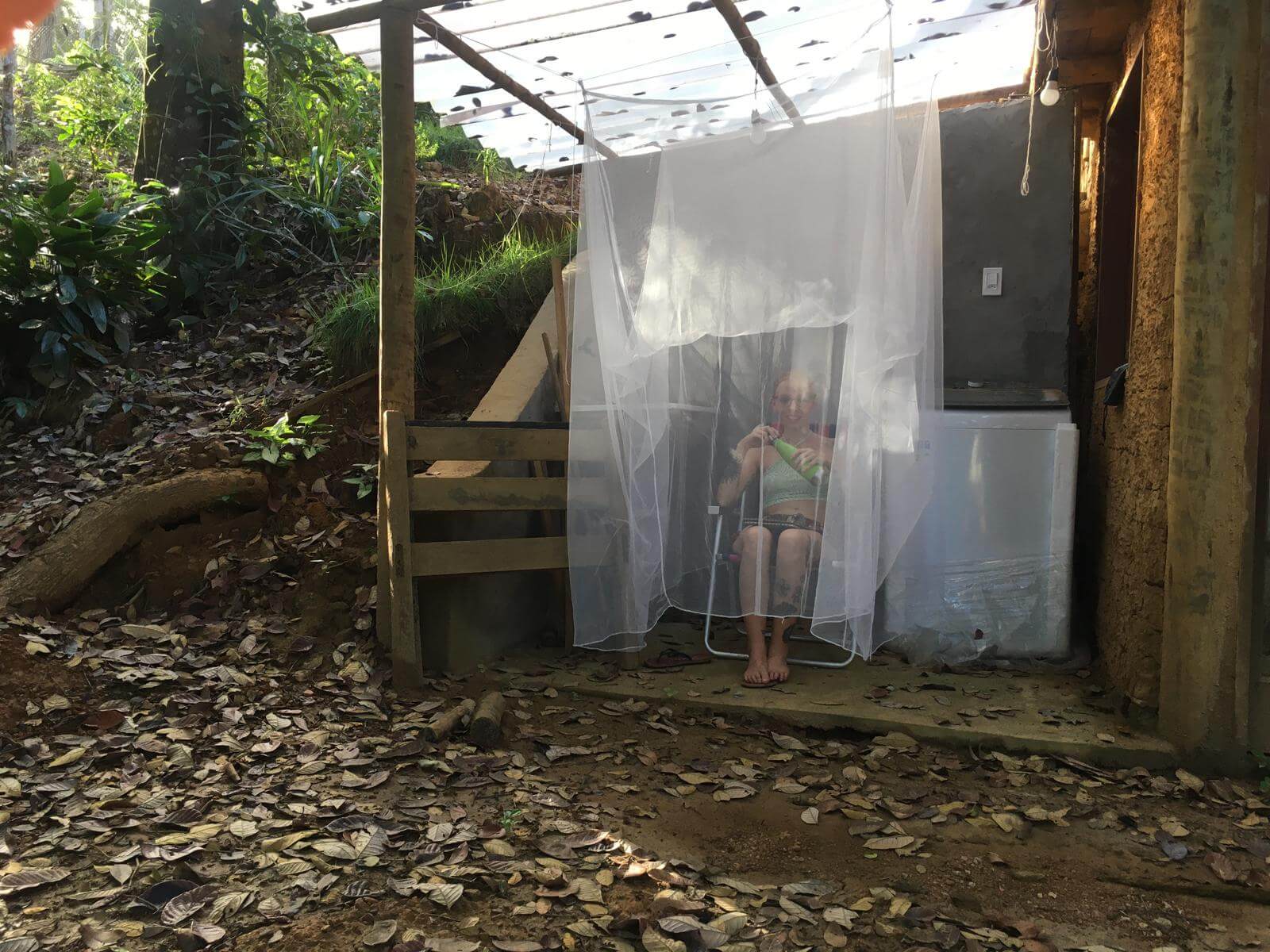 Laura sat protected inside a hanging mosquito net in the jungle in Brazil