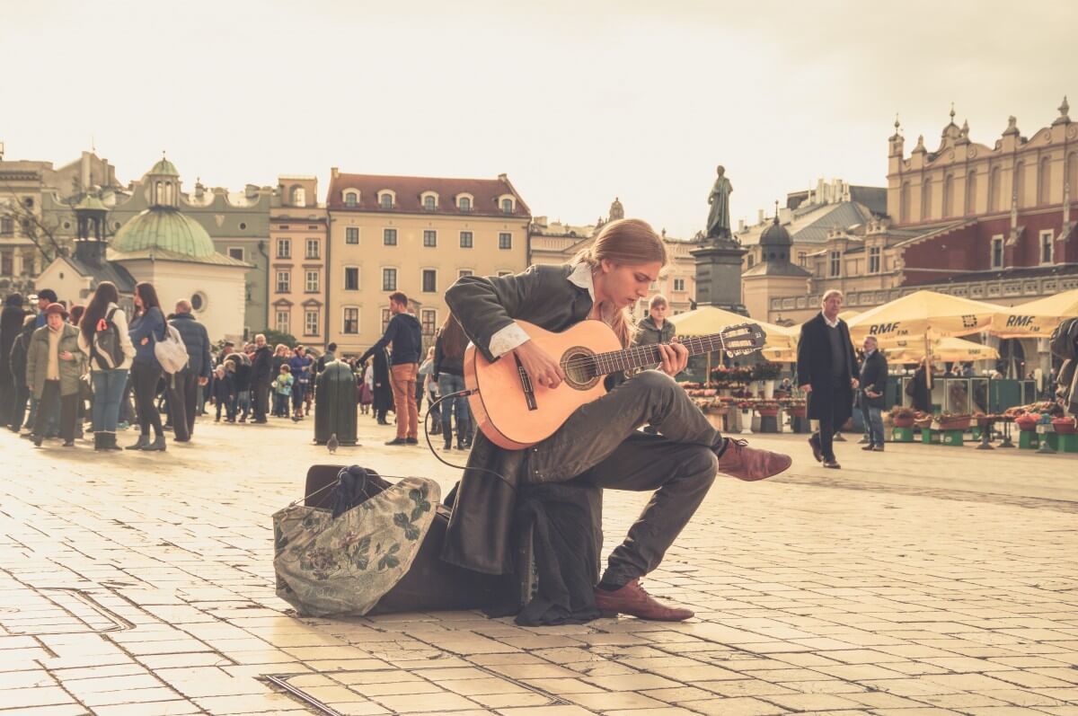 street performer in europe playing his traveling guitar