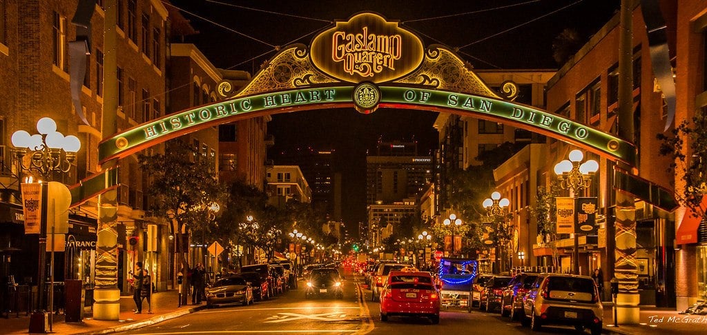 a street in San Diego at night, lit up with signage and lights