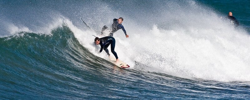 Surfer snakes another's wave