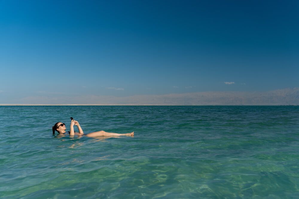 Woman enjoying her mobile internet in Israel in the Dead Sea