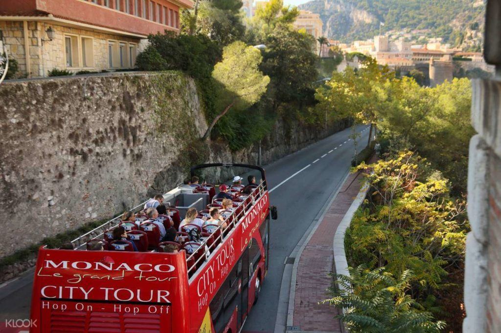 people sitting on the red Pop on and off Bus tour in Monaco