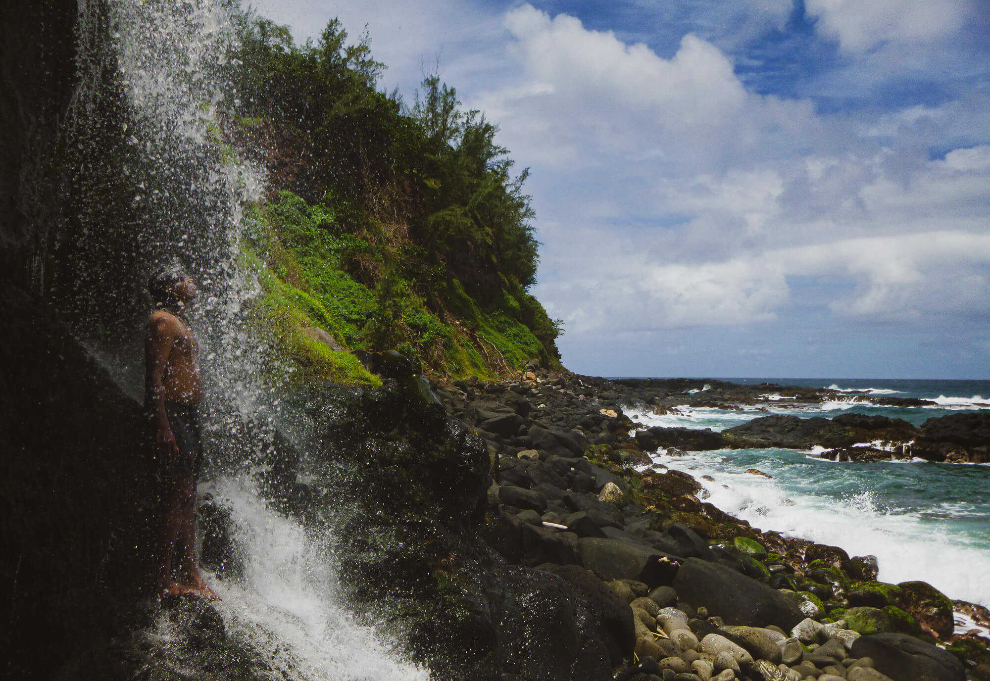 Enjoying a waterfall while hiking on a Mauritius wild beach in the south