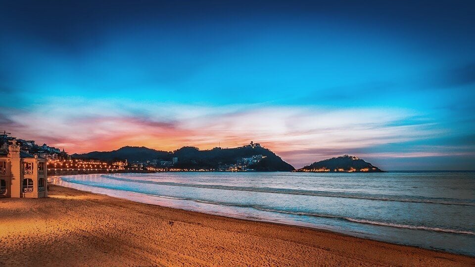 a pink and blue sunset on a beach in San Sebastián in spain