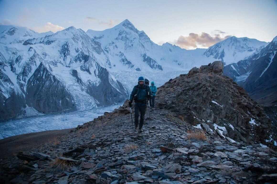 People hiking in winter in the snow covered mountains in down jackets