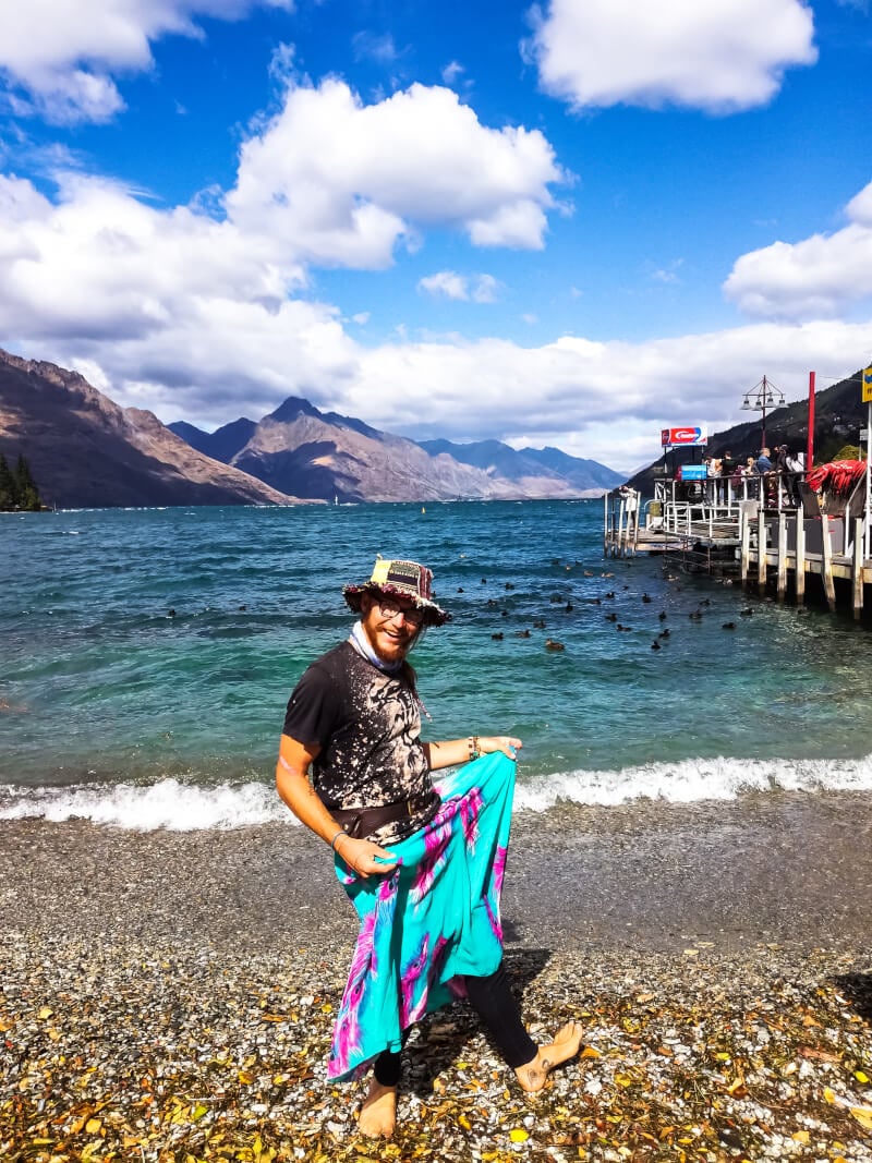 Backpacker in Queenstown posing for a photo in front of the waterfront