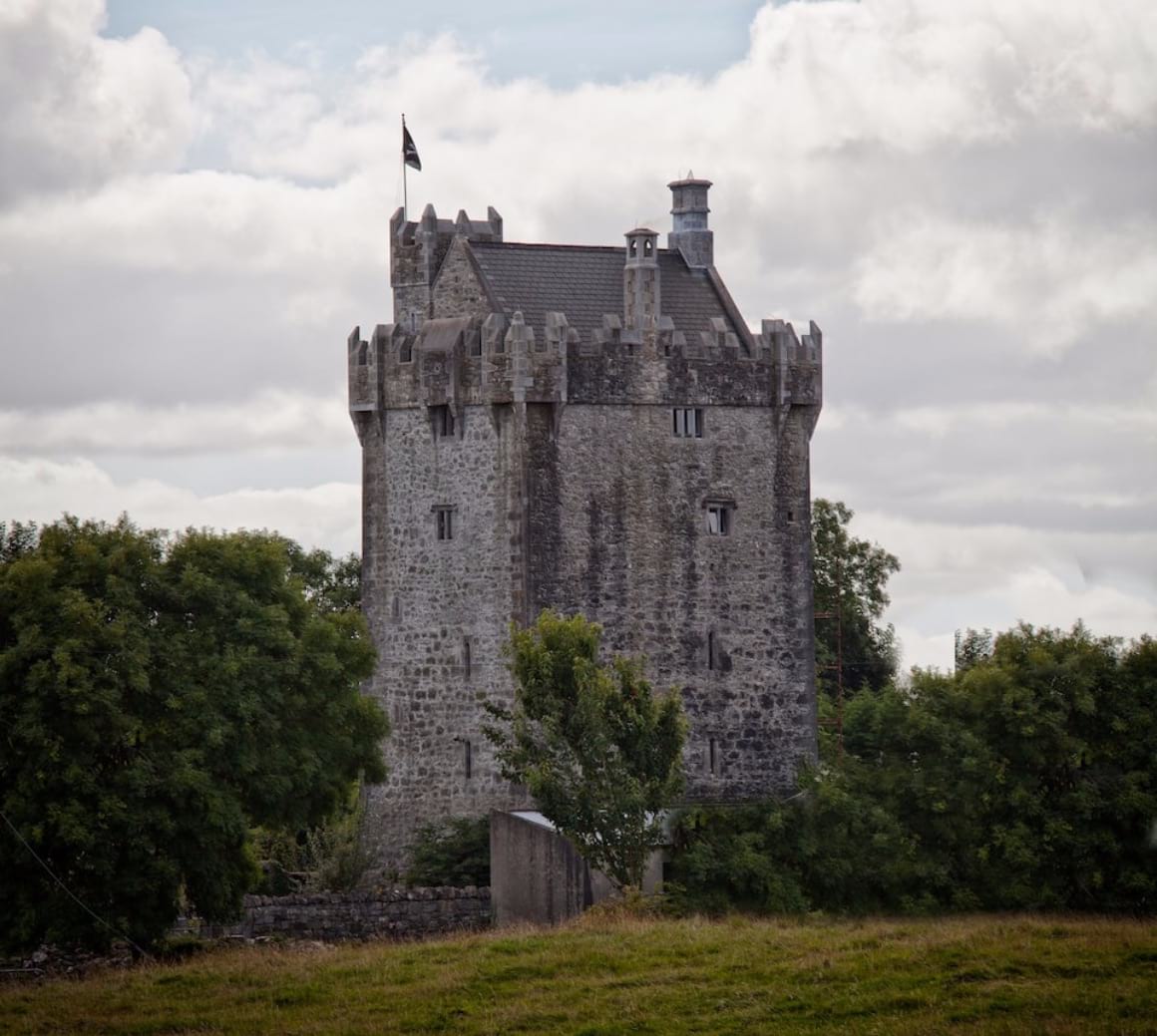 Stone fortress nestled within a verdant prairie surrounded by lush trees