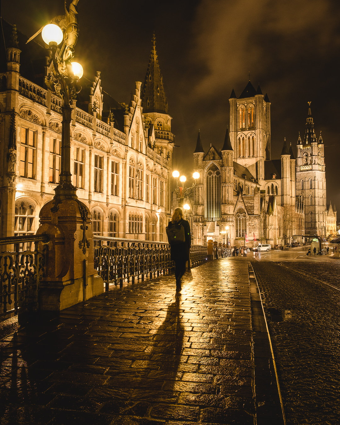 a woman walks past a bridge in Ghent, Belgium