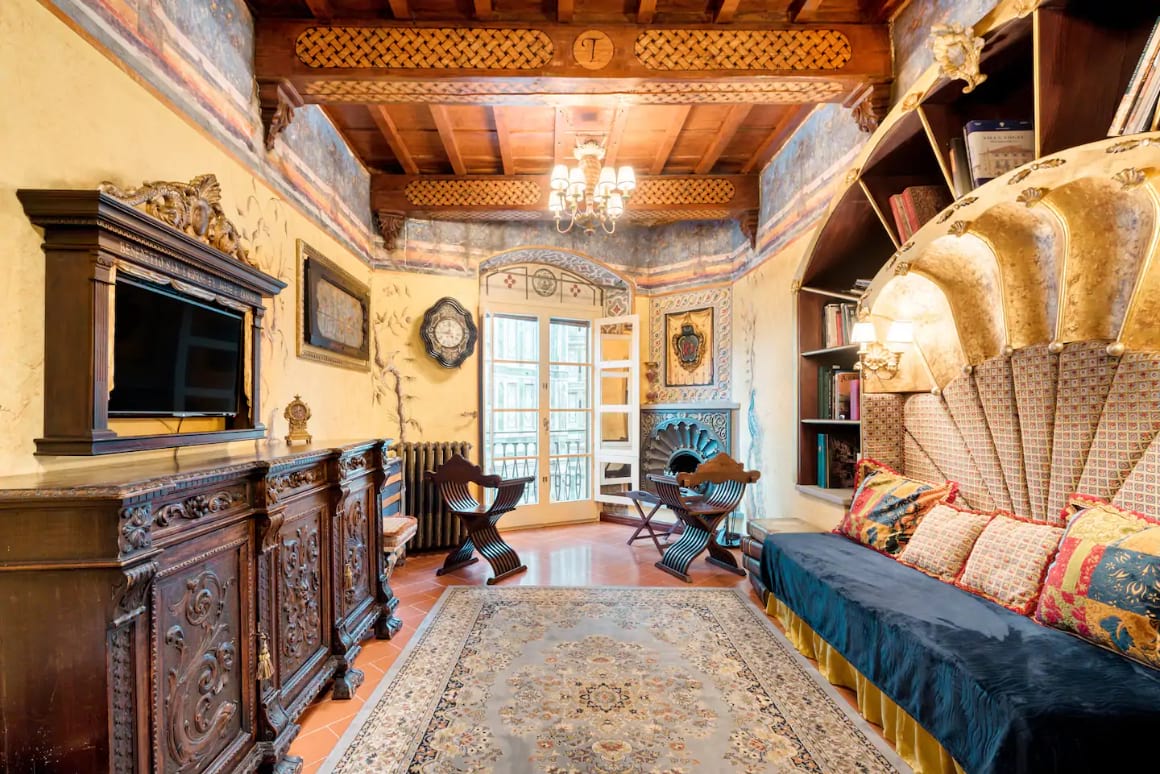 Extravagant, Renaissance styled lounge room with wooden ceiling and large rug. 
