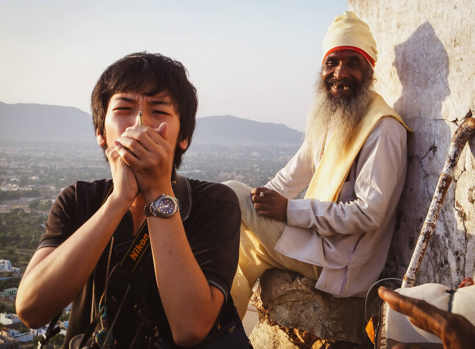 A backpacker travelling India smokes weed with an old local man