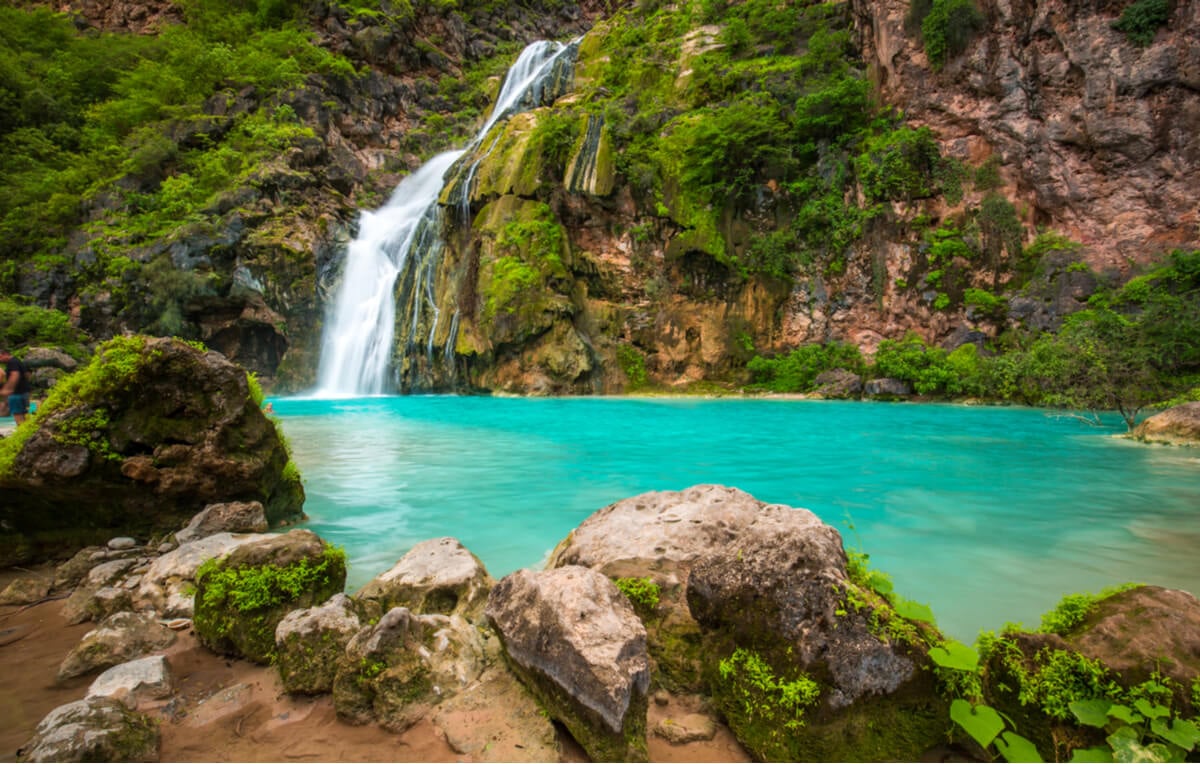 bright blue waterfall seen while backpacking oman