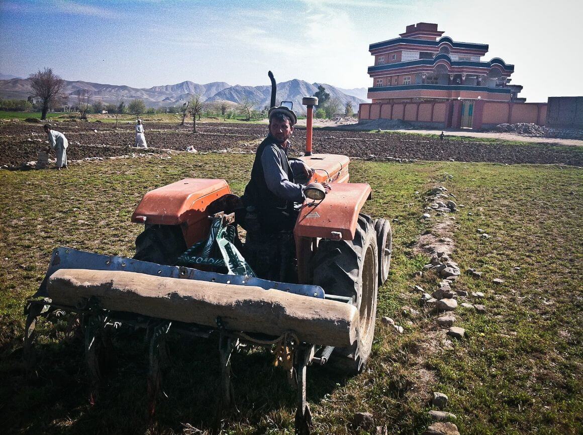 A man sits on his tractor in Afghanistan.