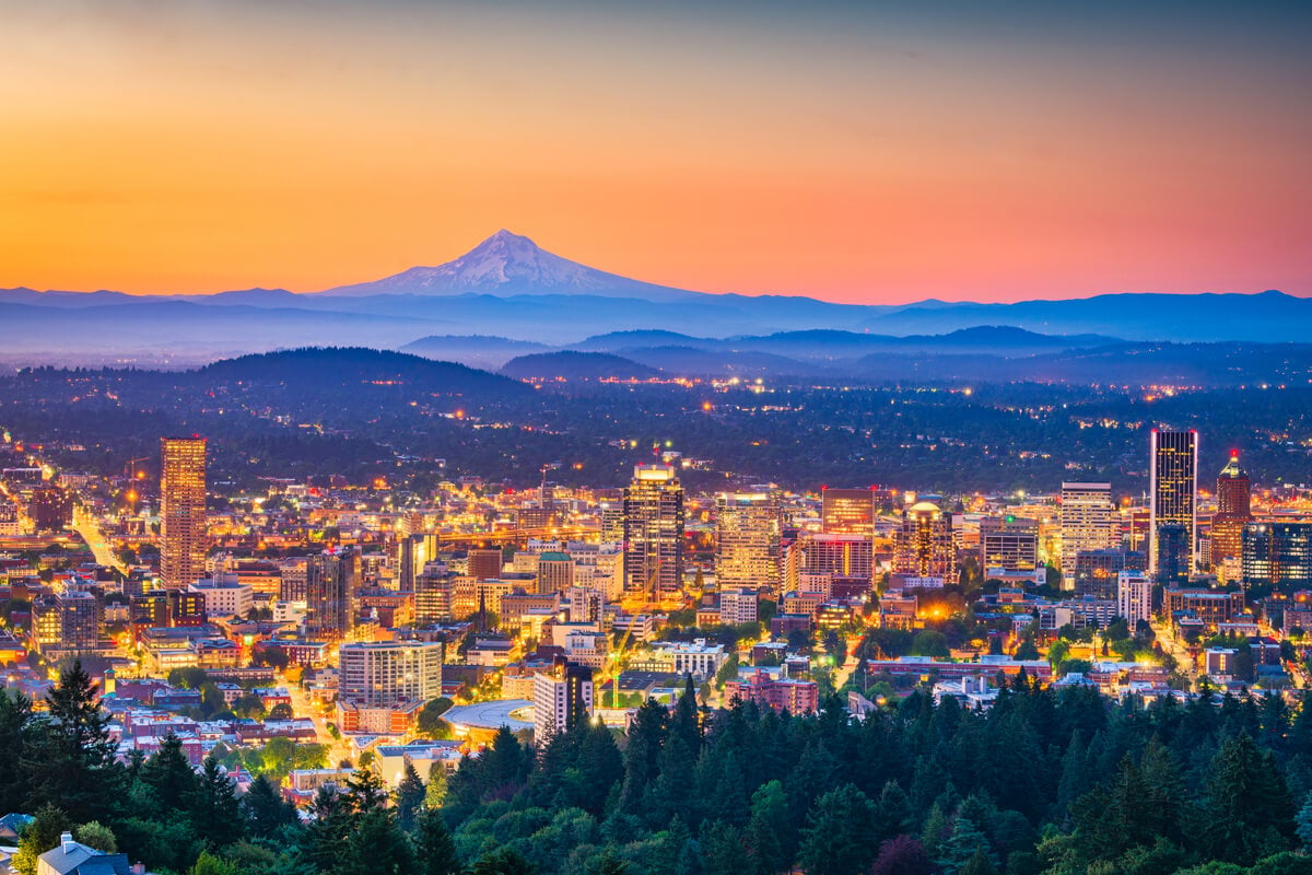 mount hood and portland skyline from a viewpoint amidst an orange pink sunset