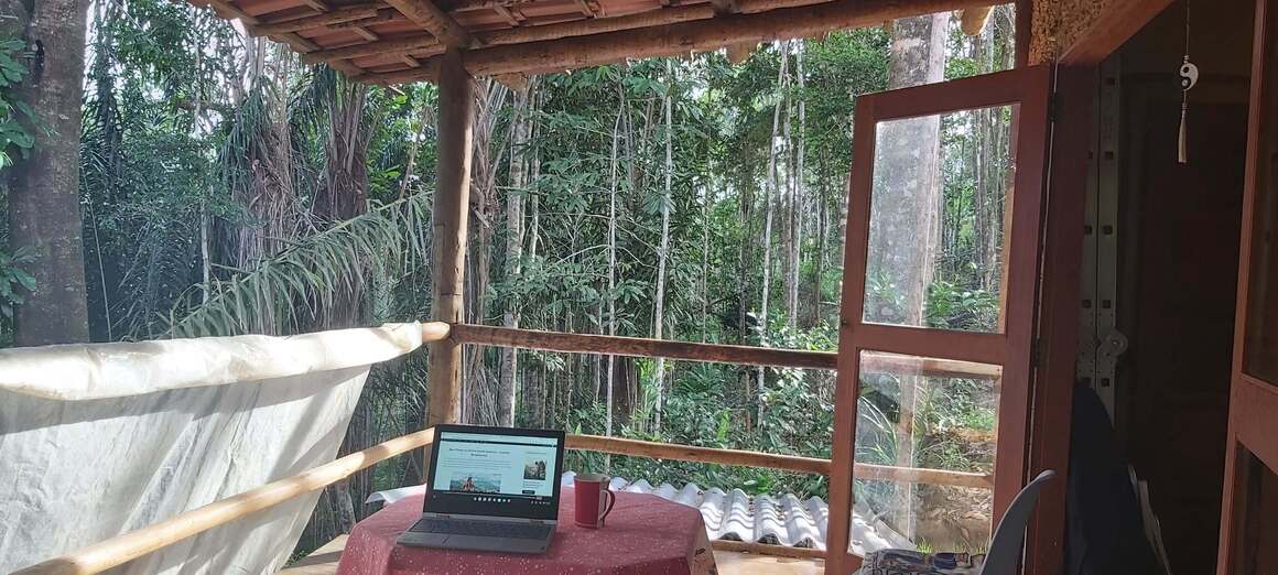 Working on a computer on a balcony of a natural house in jungle