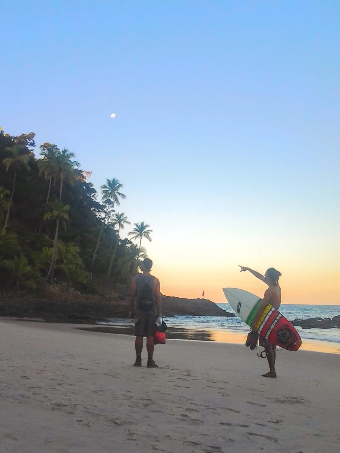 Surfers on the beach in Itacare, Brazil at sunset