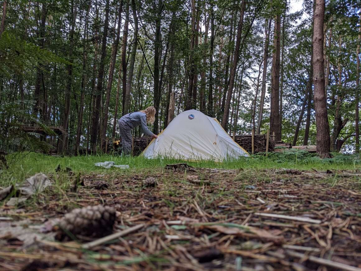 Laura opening the Big Agnes Tiger Wall UL 2 in a clearing in the woods in the United Kingdom