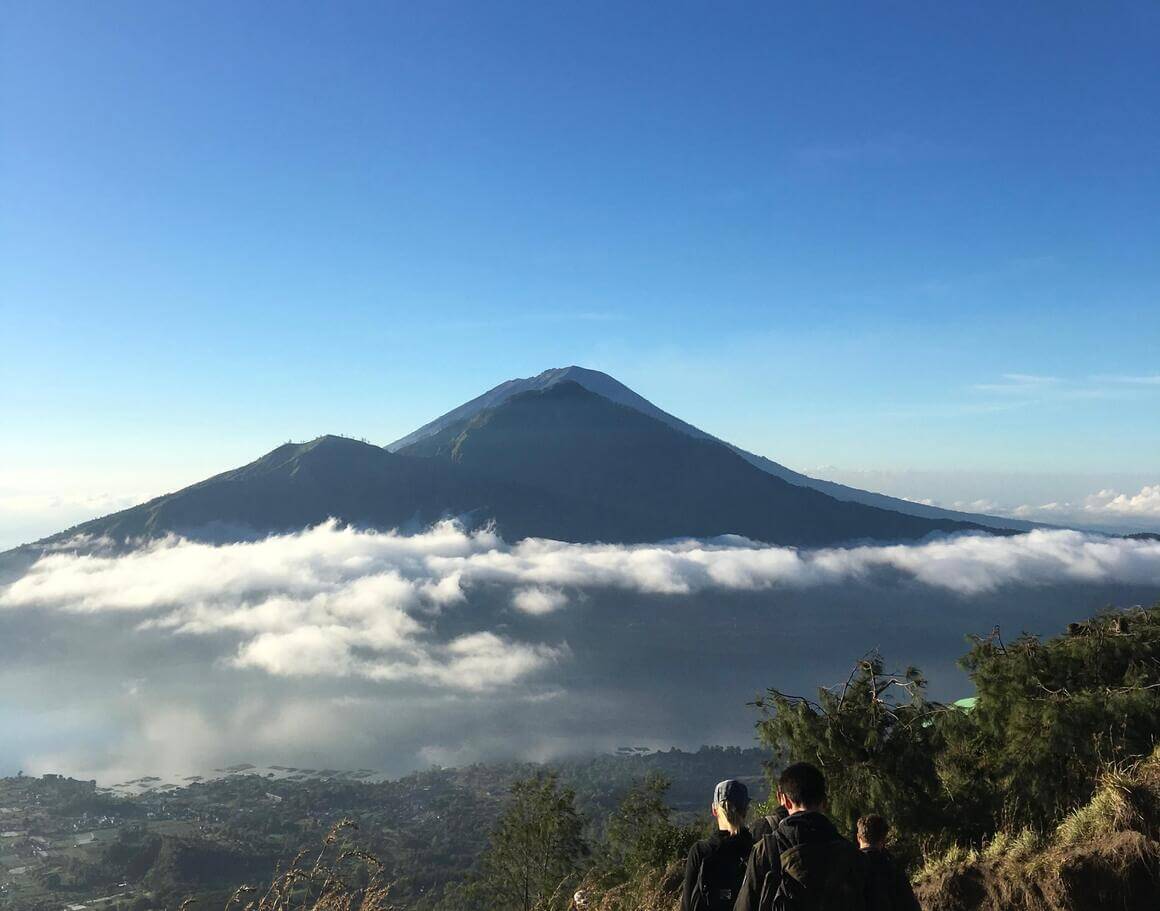 Mount Batur volcano in bali indonesia on a sunny day with blue sky and some clouds in the middle 