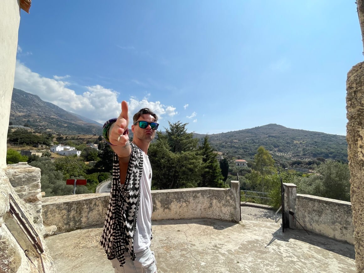 a guy making a hand gesture at the camera while on a Roadtrip  in Crete Greece