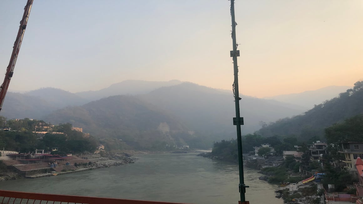 orange sunset over the hills of rishikesh india as seen from the famous bridge