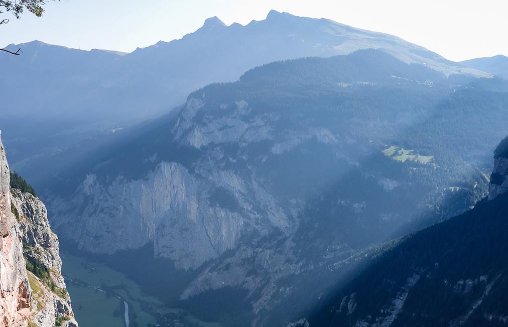 Looking down the Lauterbrunnen valley towards the alps with light streaming over the peaks. Interlaken, Switzerland.