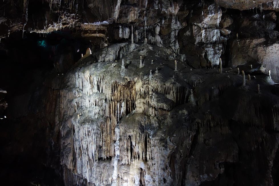 The inside of a cave with centuries of build up of stalactites and stalagmites.