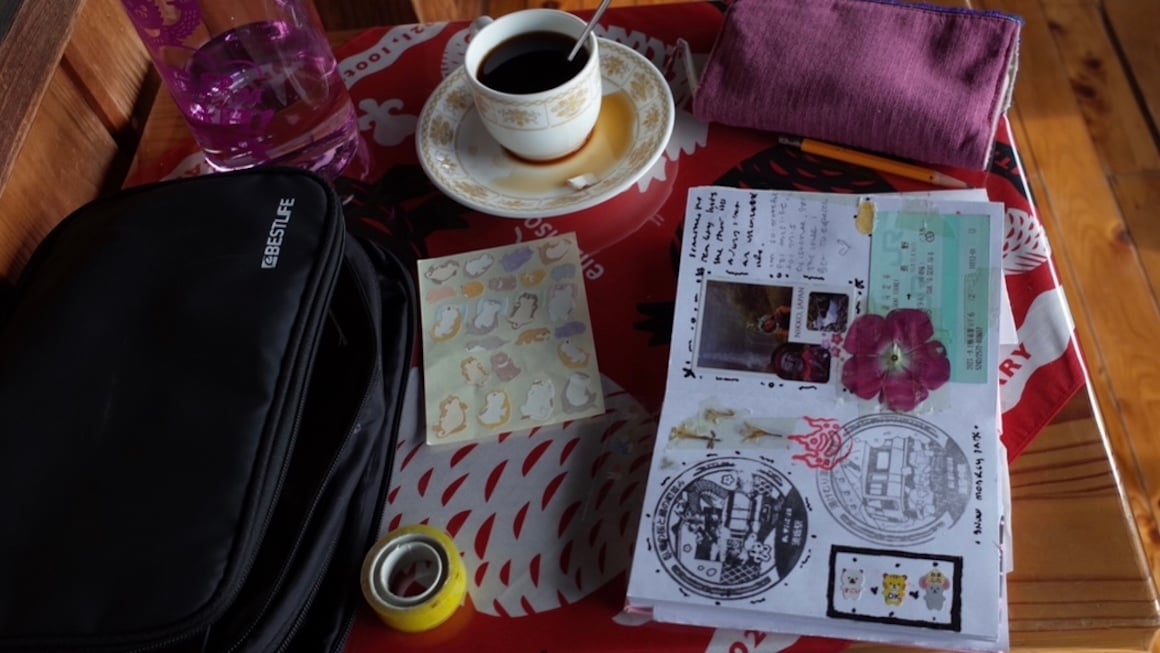 A cup of coffee and a journal on a cafe table in Japan.