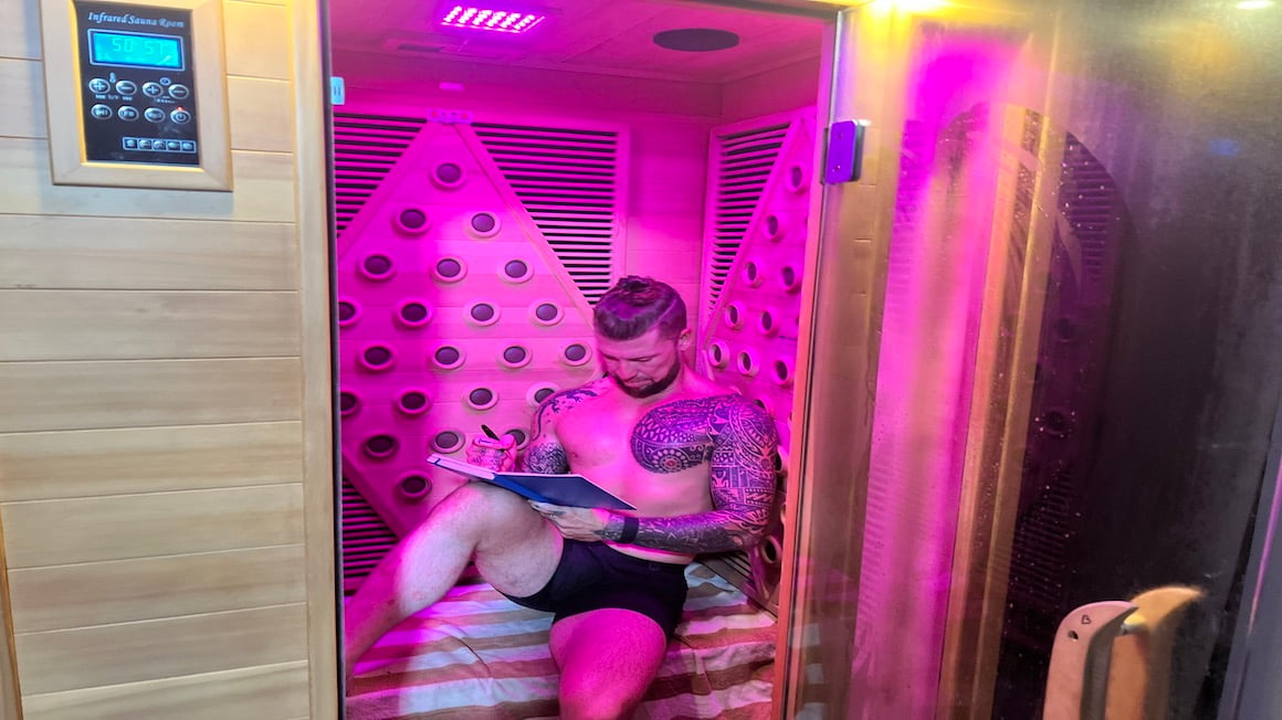 will sitting in an infrared wooden sauna writing in his journal