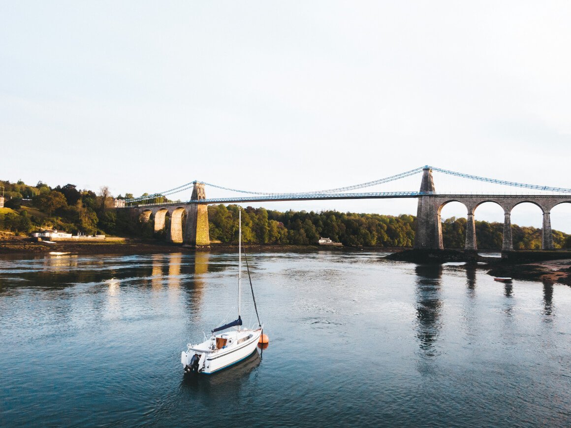 White boat along the waters of the Menai Strait, near the Menai Bridge in Bangor, Wales.