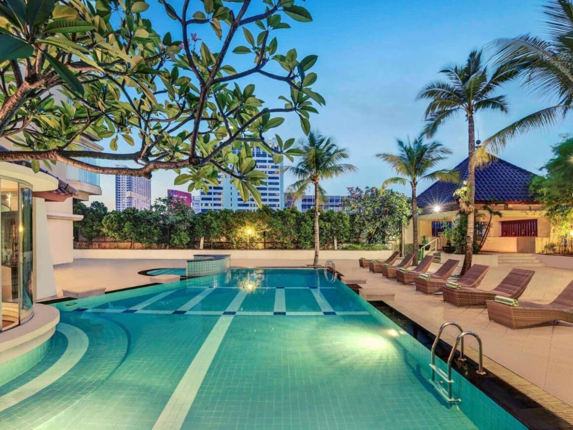 Frangipani trees over a bottom lit pool at the Mercure Jakarta Kota Hotel