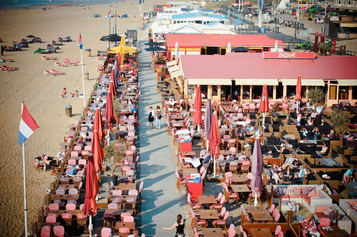 Beachfront restaurant with a busy outdoor seating area in the town of Scheveningen, The Hague, Netherlands