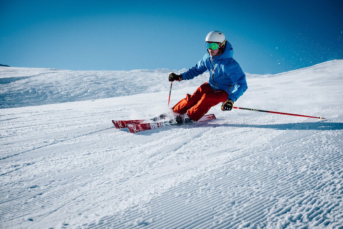 a person skiing down a ski slope with gondolas in the background