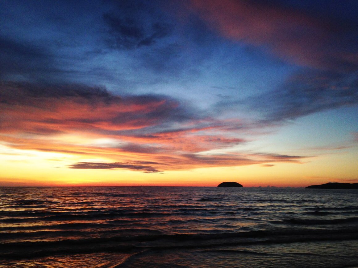 Sunset with orange and blue skies on one of the beaches in Kota Kinabalu