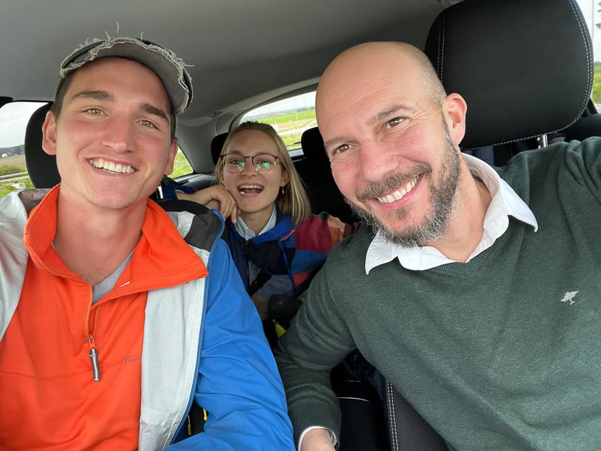 a couple hitchhiking in a car with a male driver