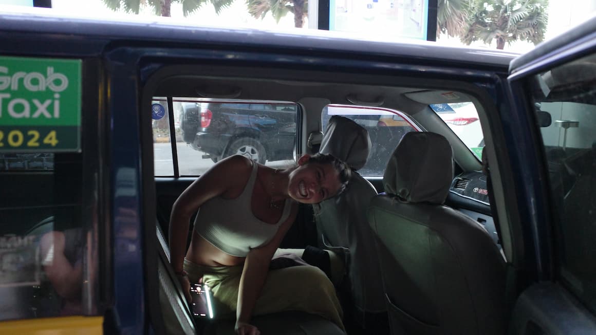 amanda smiling in the backseat of a grab taxi in myanmar