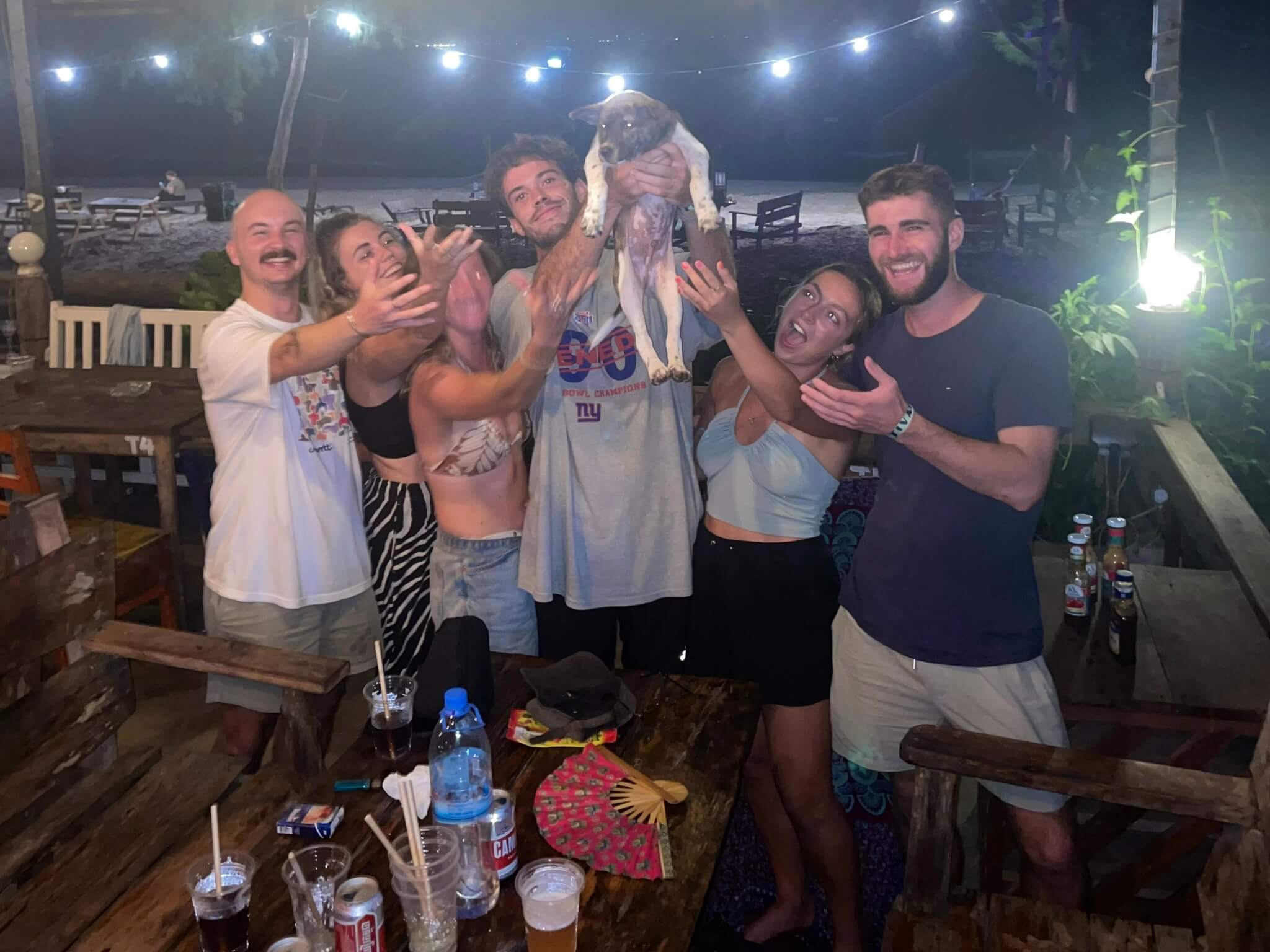 friends holding up a puppy in koh rong