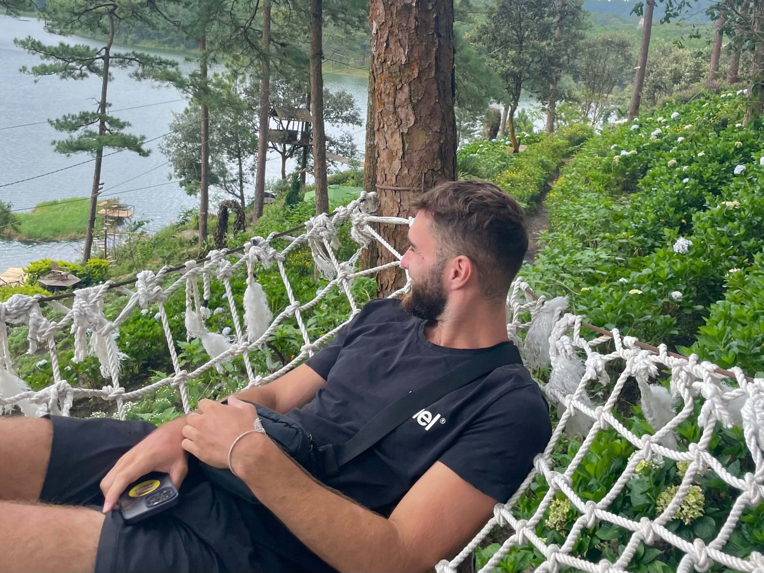 a guy chilling in a hammock by a lake in da lat