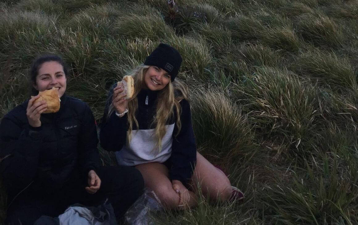 Dani and her friend enjoying a sandwich break after their hike.