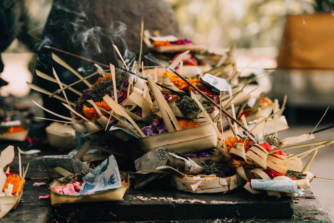 Canang sari offerings with burning insense at a shrine in Bali