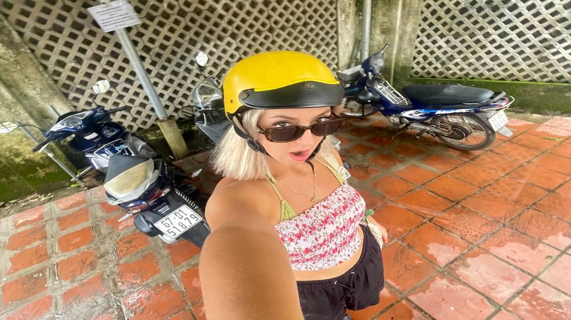 A woman with a helmet on posing with motorbikes in Phu Quoc